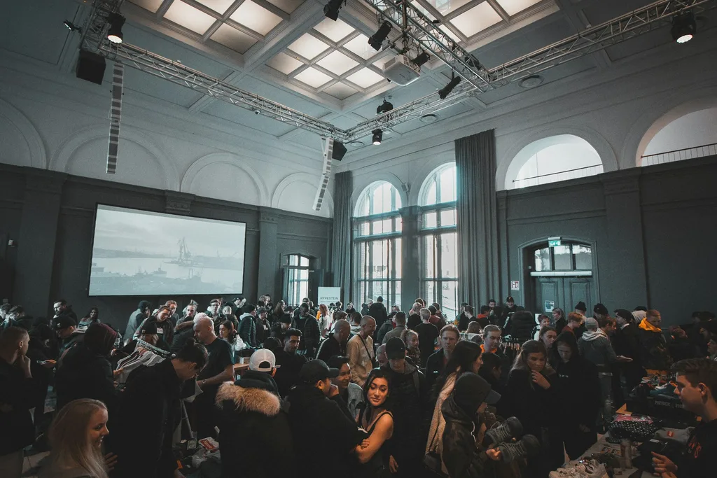 Crowd gathered in a large hall with a projection screen