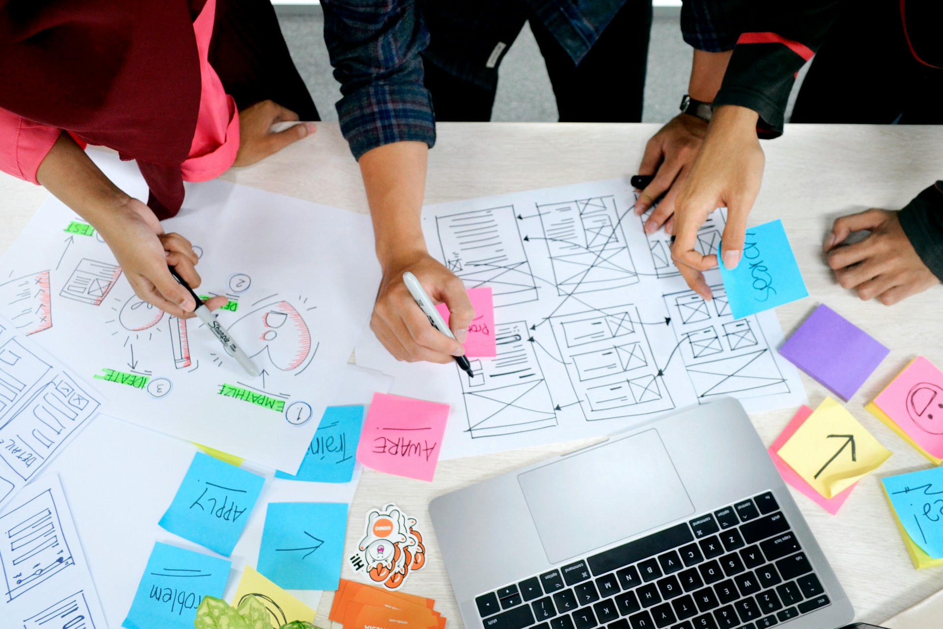Team sketching wireframes with sticky notes on a table