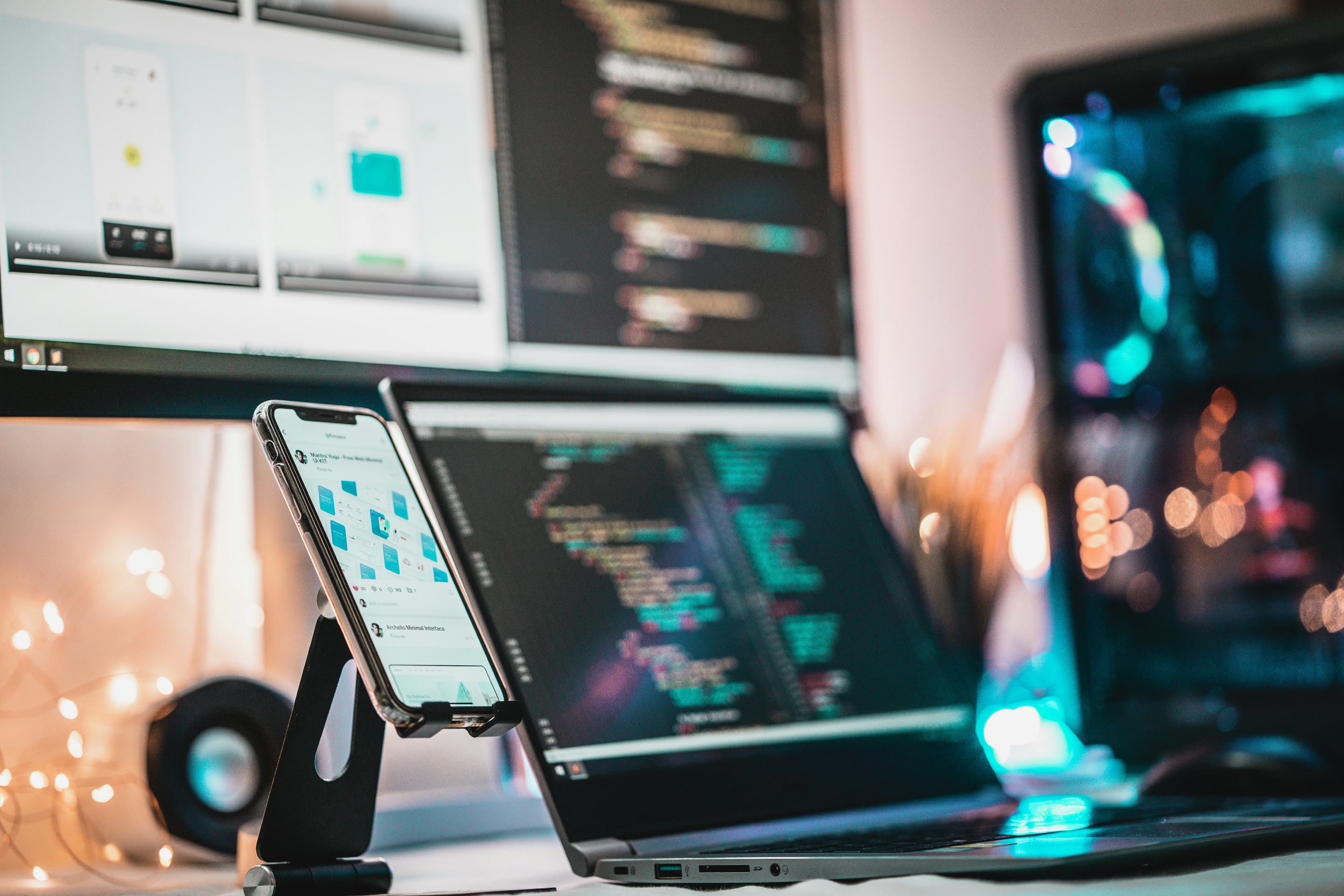 Phone, laptop and monitor displaying app designs and code