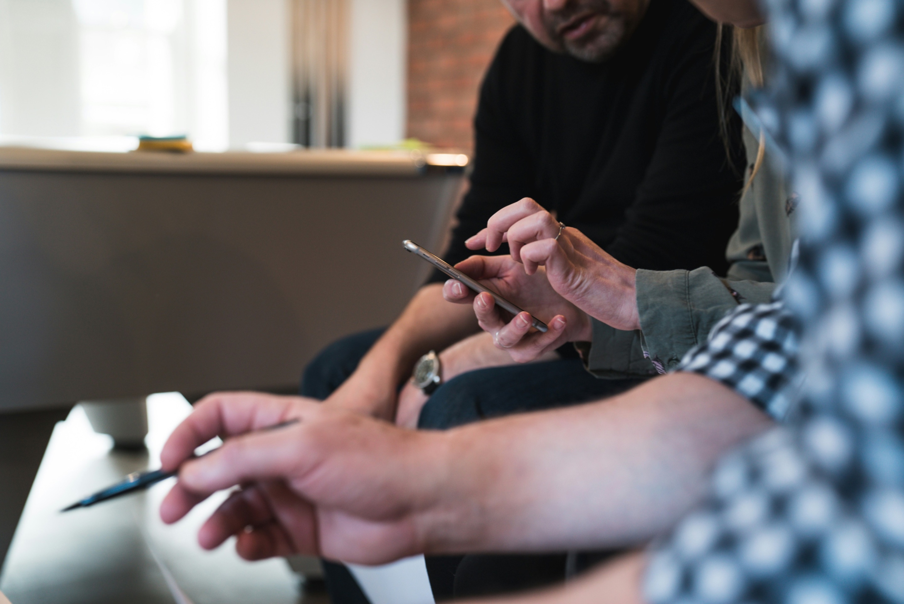 Colleagues pointing at a smartphone during a discussion