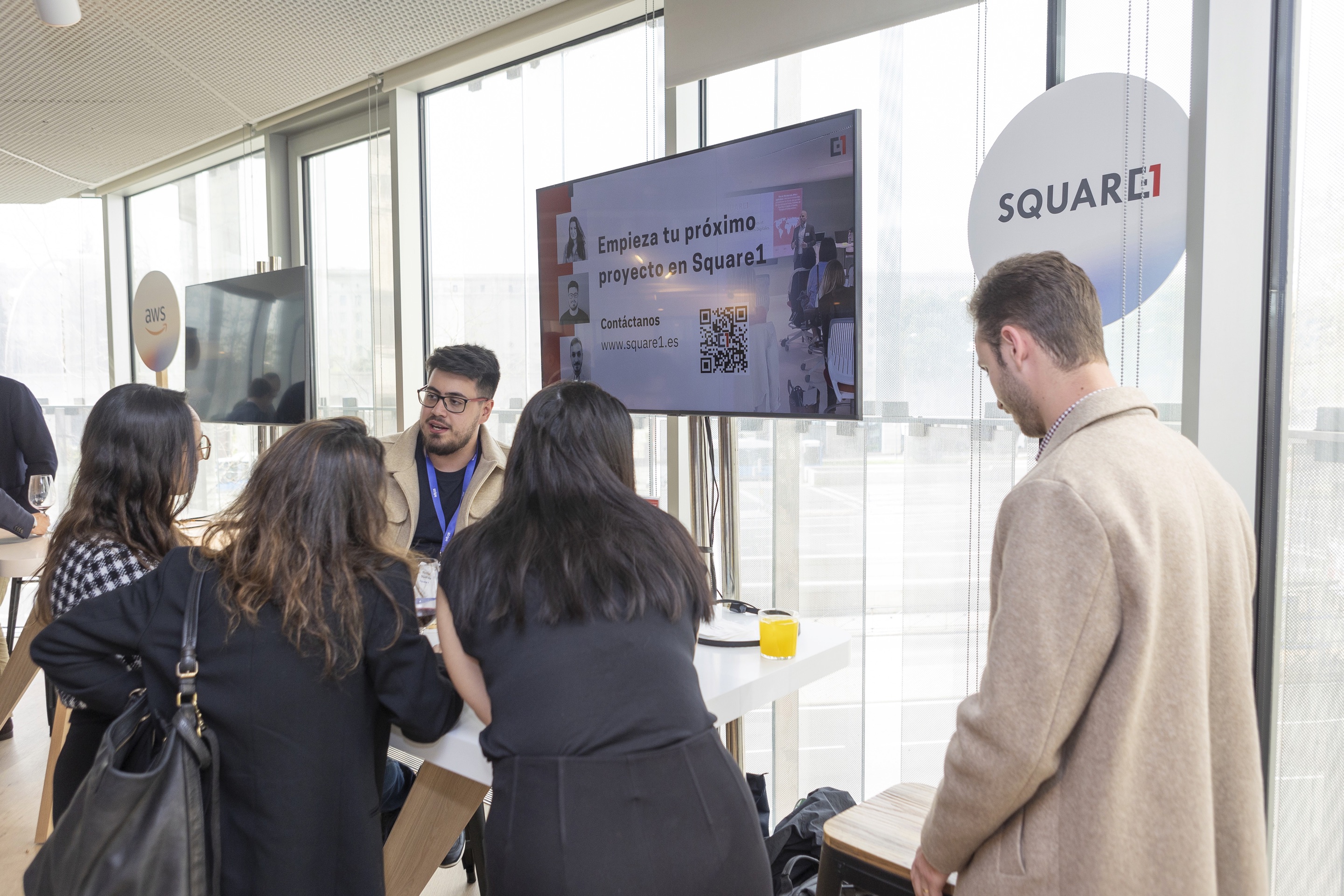People gathered at a Square1 stand with a presentation screen