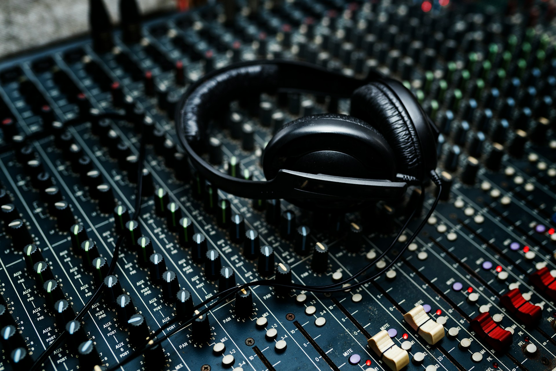 Headphones resting on an audio mixing console