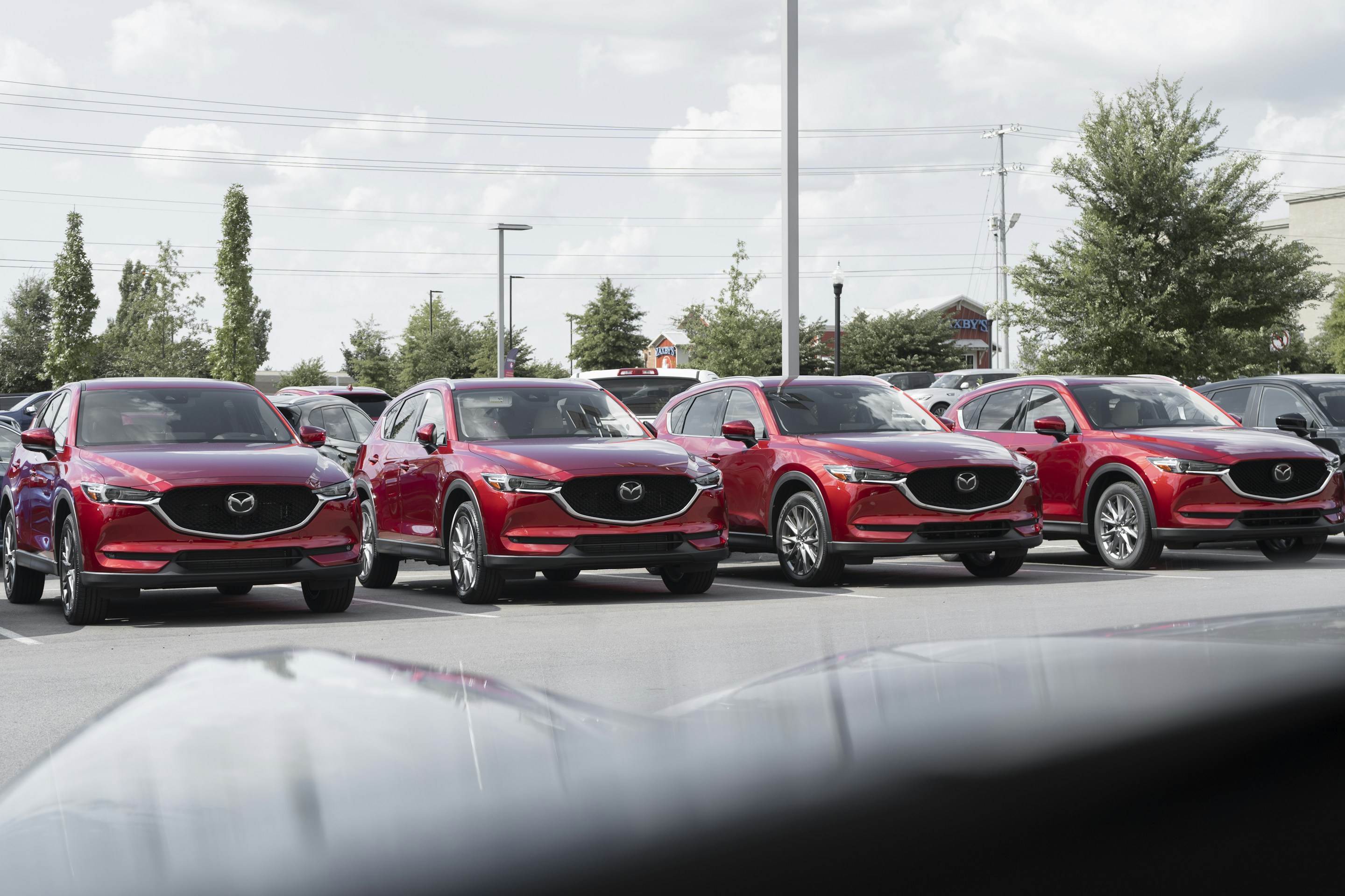 Row of red SUVs lined up on a dealership forecourt