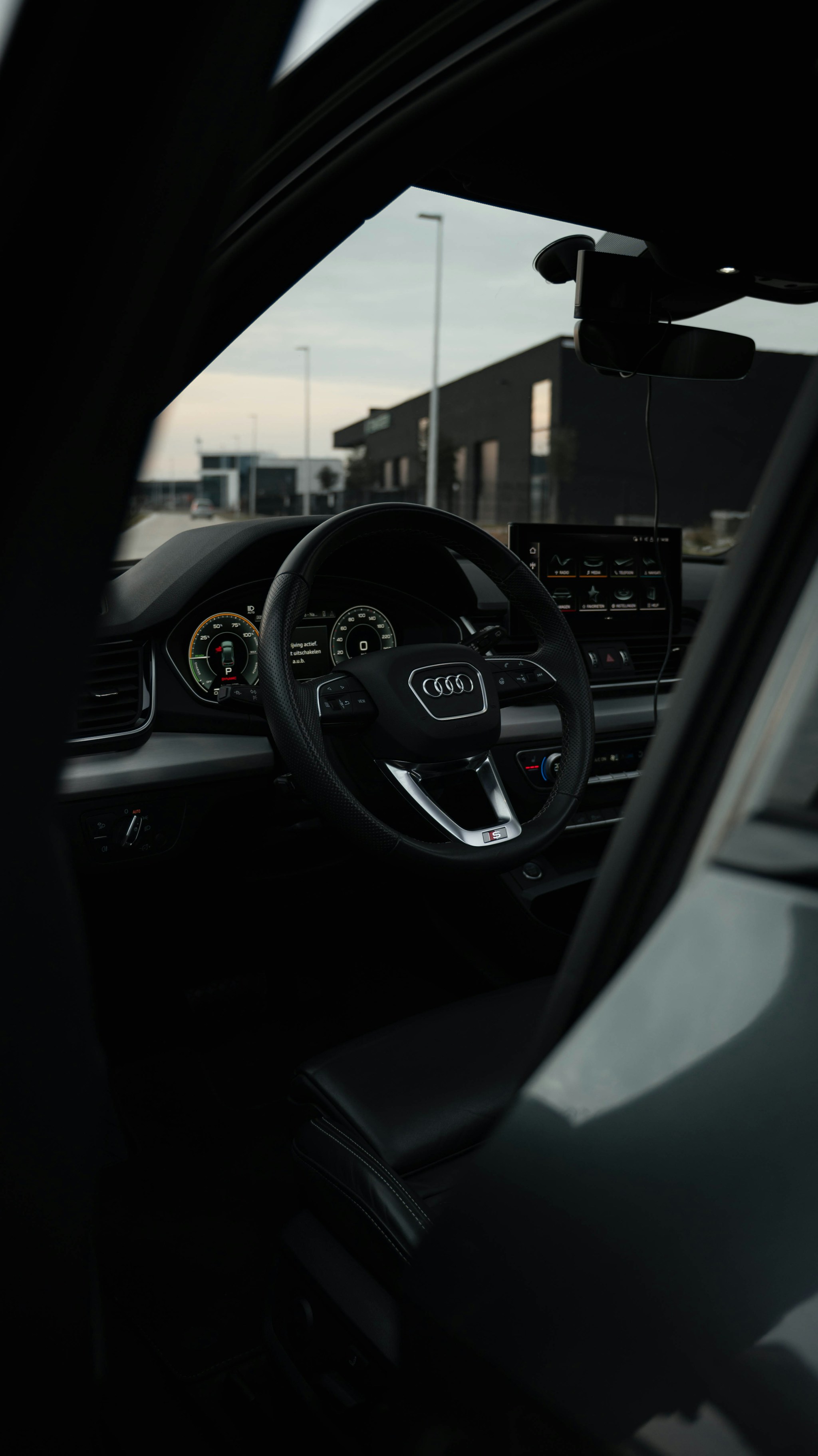 View through an open car door of the steering wheel and dashboard