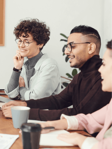 Colleagues smiling during a meeting at a table