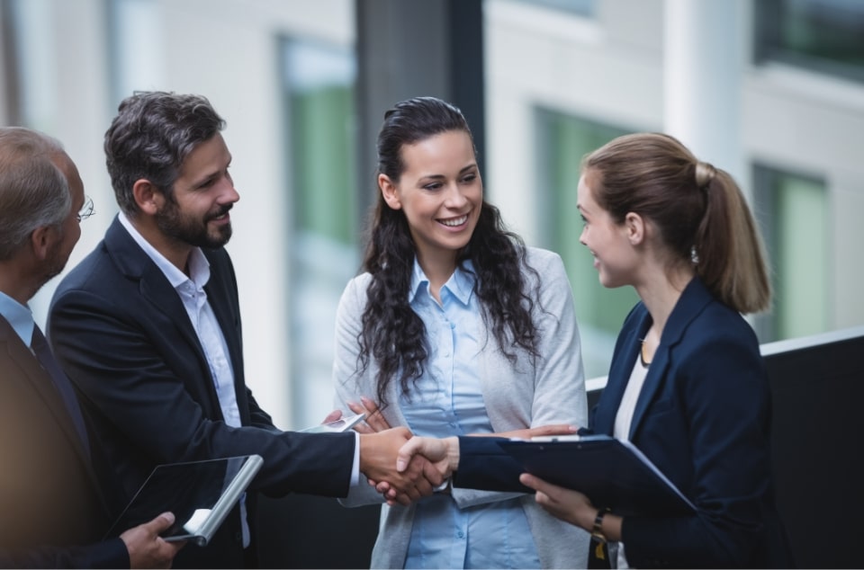 Business people shaking hands outside an office building