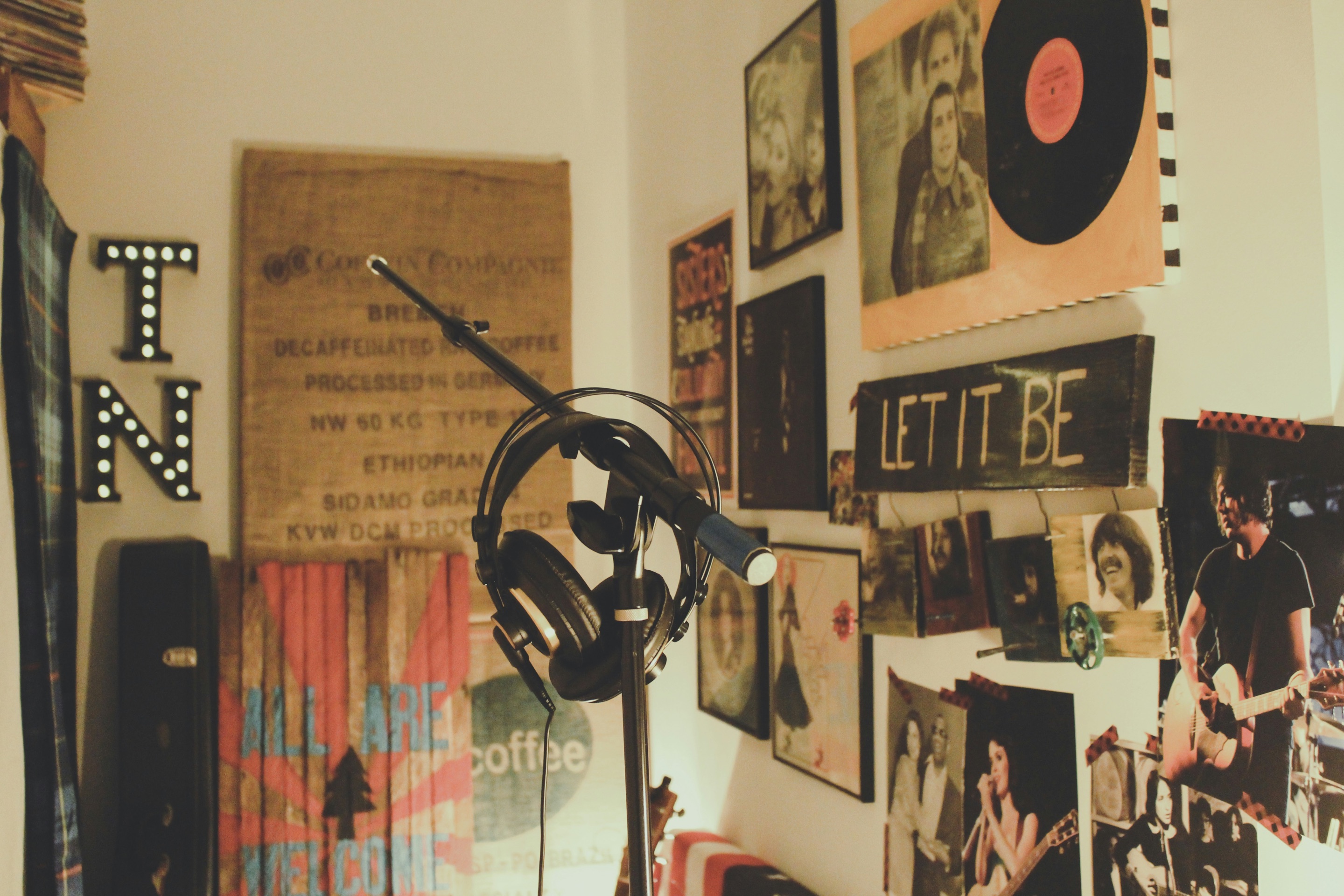 Headphones on a microphone stand in a room covered in music posters