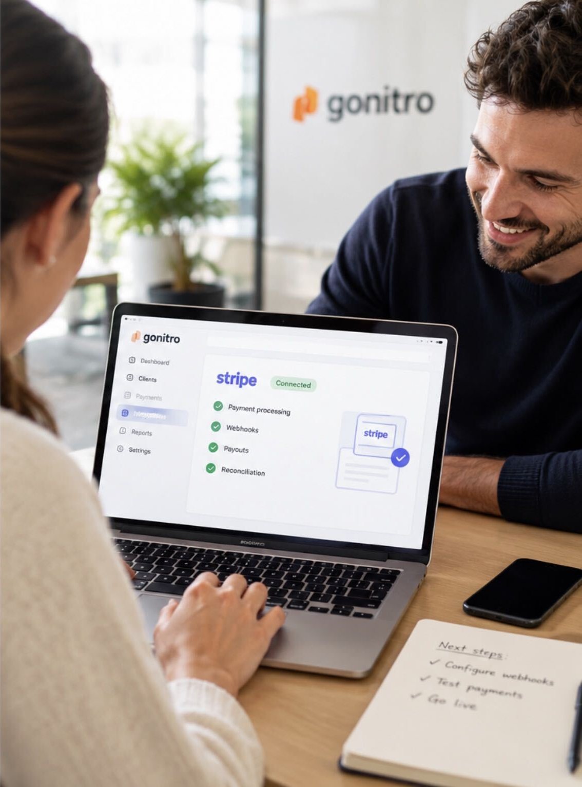Two colleagues smiling over a laptop showing a connected Stripe integration