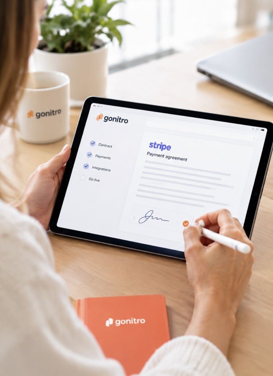 Person signing a Stripe payment agreement on a tablet with a stylus