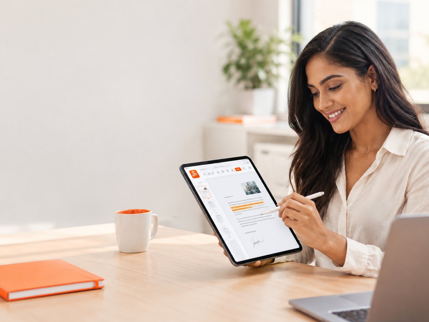 Smiling woman annotating a document on a tablet at her desk