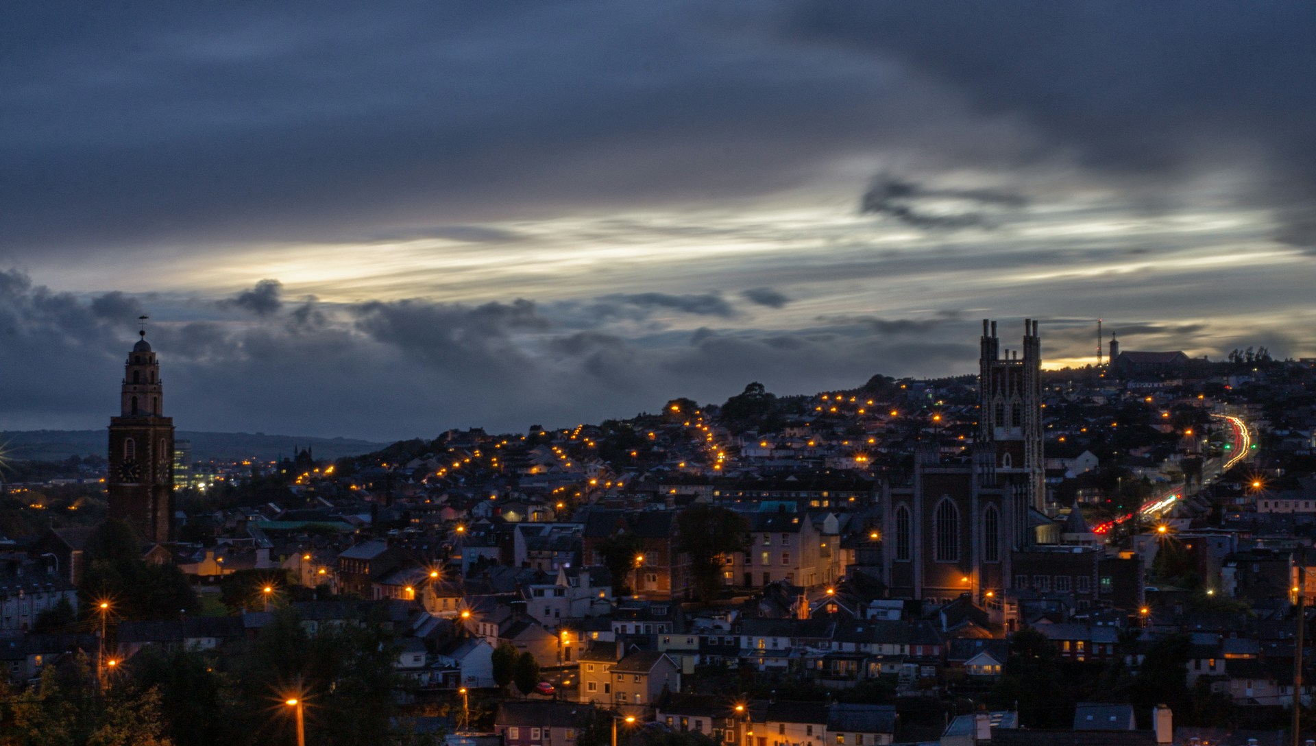City skyline with church towers and street lights at dusk