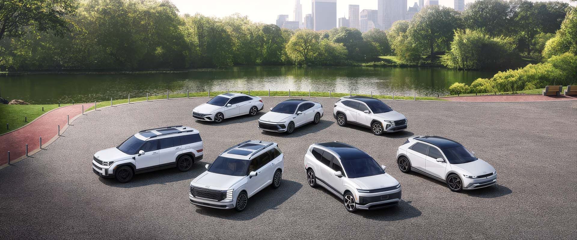 White Hyundai cars and SUVs parked in a circle beside a park lake