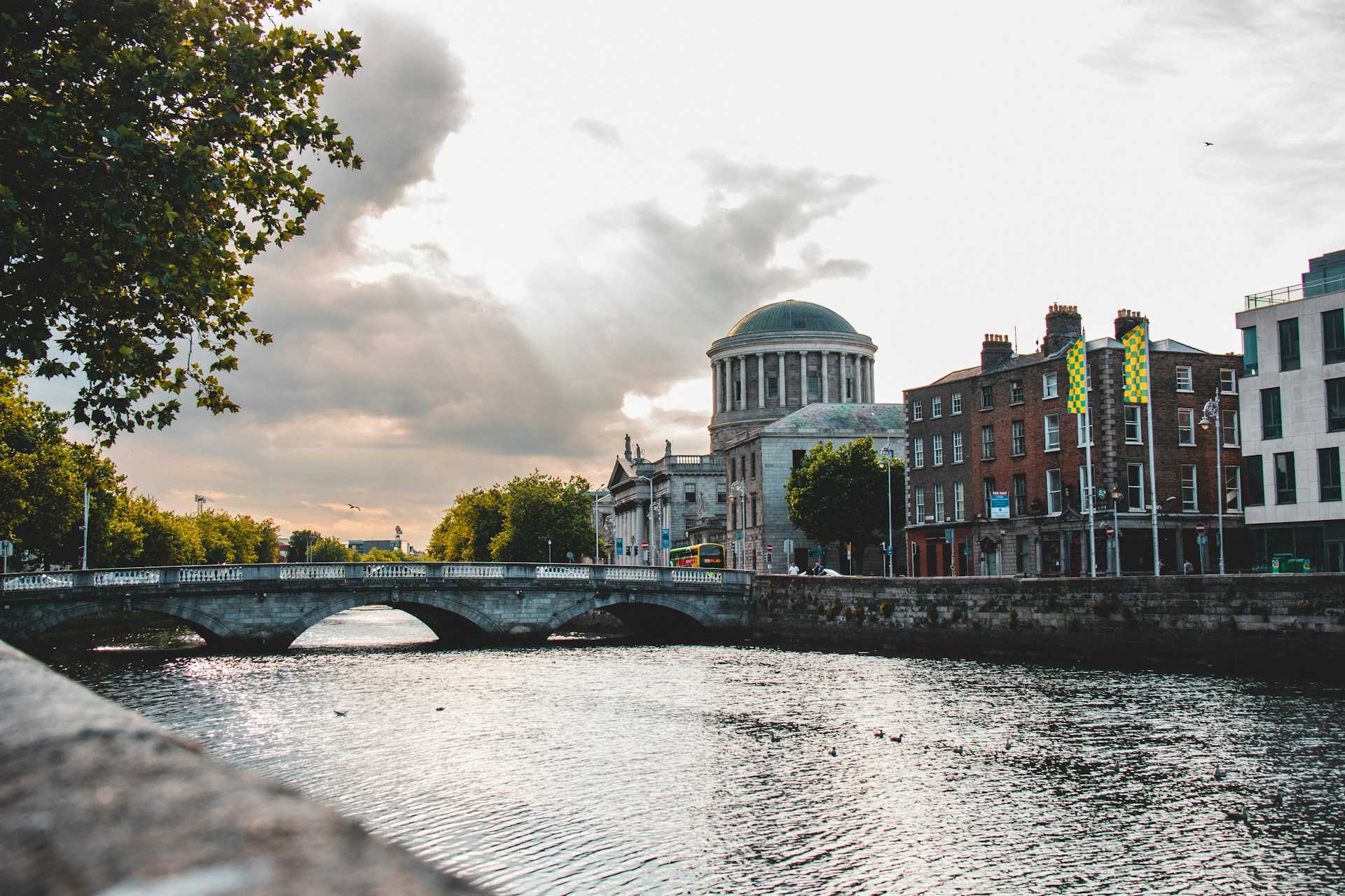 Domed building and arched stone bridge on a city river