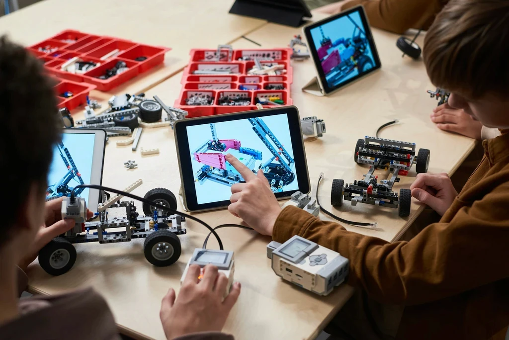Children building robots with construction kits and tablets